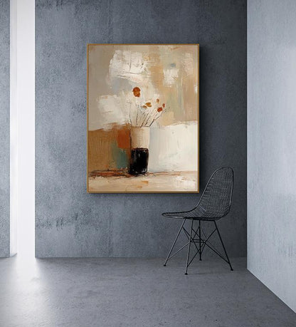 May include: Abstract painting in a gold frame featuring a vase with flowers. The artwork uses a palette of beige, brown, and white. A black wire chair is positioned to the right of the painting, against a gray wall.