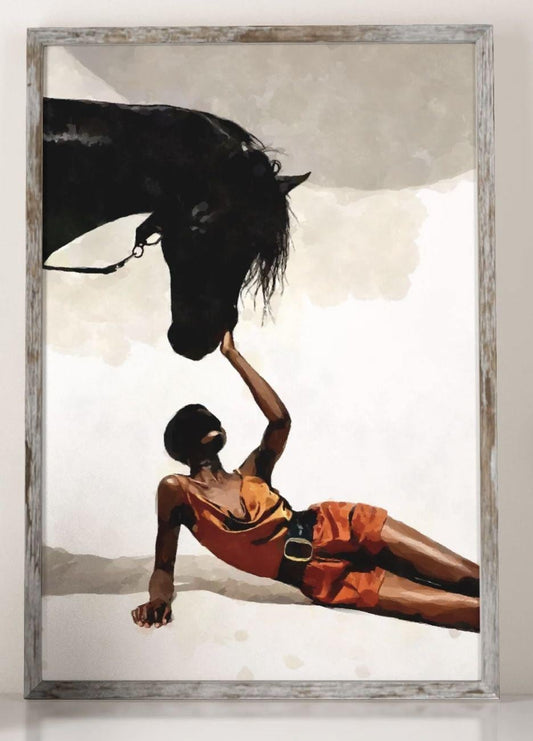 May include: Art print of a black horse and a person in orange clothing. The person is lying down, reaching up to touch the horse's head. The horse is black, and the background is a neutral color. The artwork is framed.