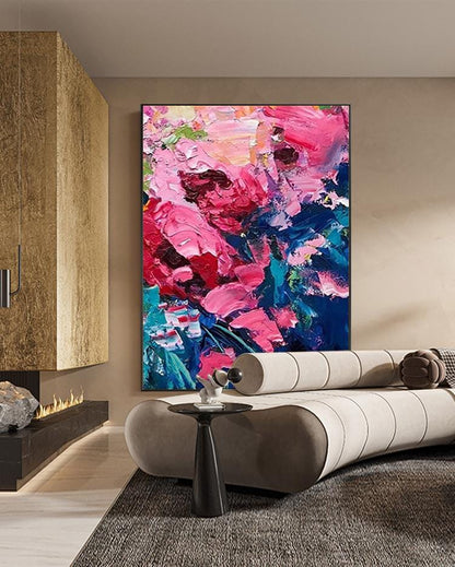 May include: Large abstract floral painting with thick brushstrokes in shades of pink, red, and blue. The artwork is framed and hangs on a neutral-colored wall. The painting is the focal point of a modern living room setting.