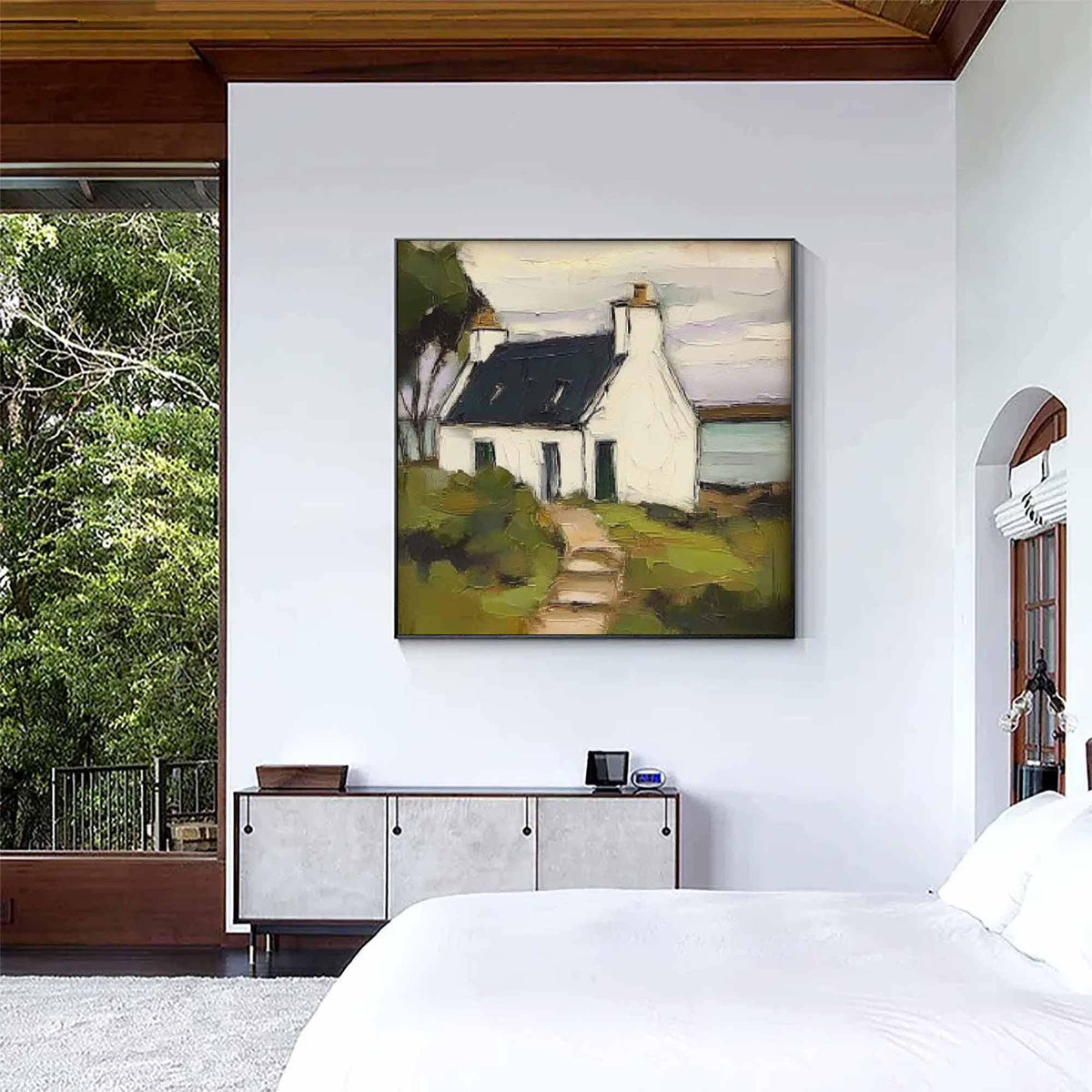 May include: A square wall art print featuring an oil painting of a white cottage with a dark roof, set against a muted sky. The scene includes a path leading to the house, surrounded by green and brown foliage, rendered with visible brushstrokes.