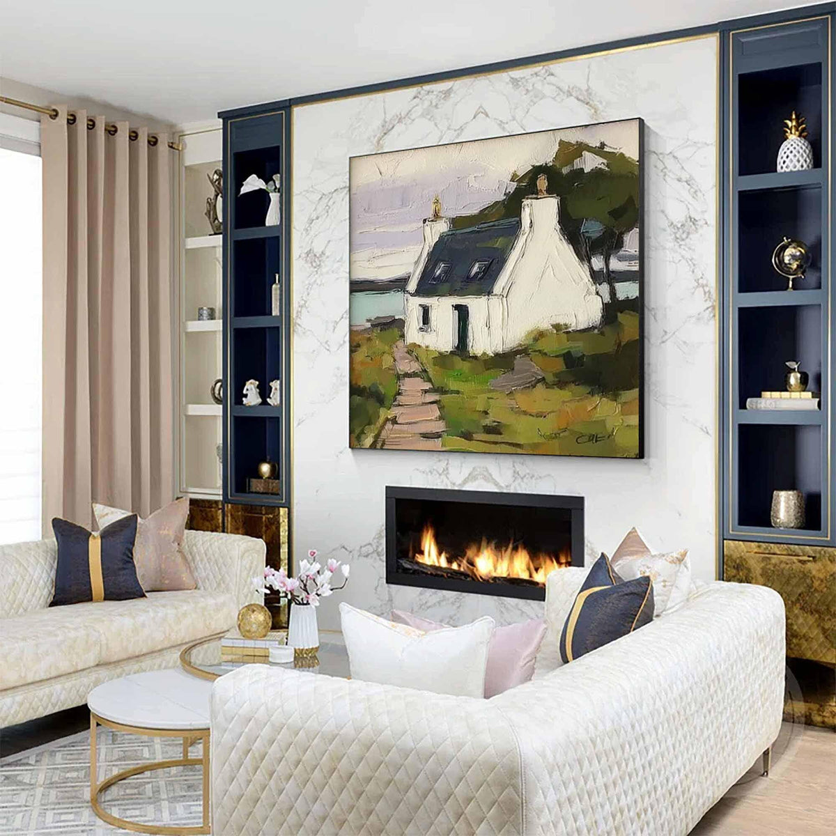 May include: A rectangular wall art painting featuring a white cottage with a dark roof, a stone path, and green landscape elements. The artwork is displayed above a fireplace on a white marble wall between two dark blue shelving units.