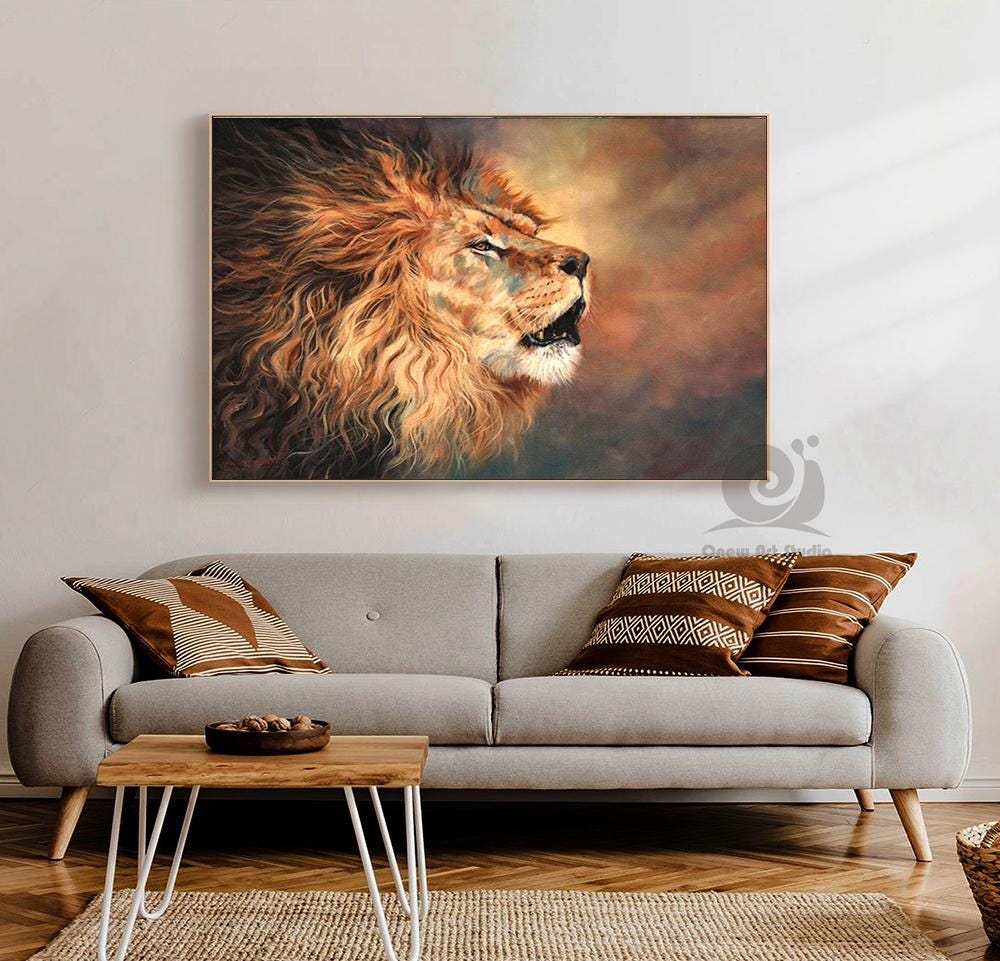 May include: A framed canvas print of a roaring lion. The lion's mane is a vibrant mix of orange and brown, with a detailed depiction of fur. The background features warm, earthy tones, creating a dramatic effect. The artwork is displayed above a gray sofa.