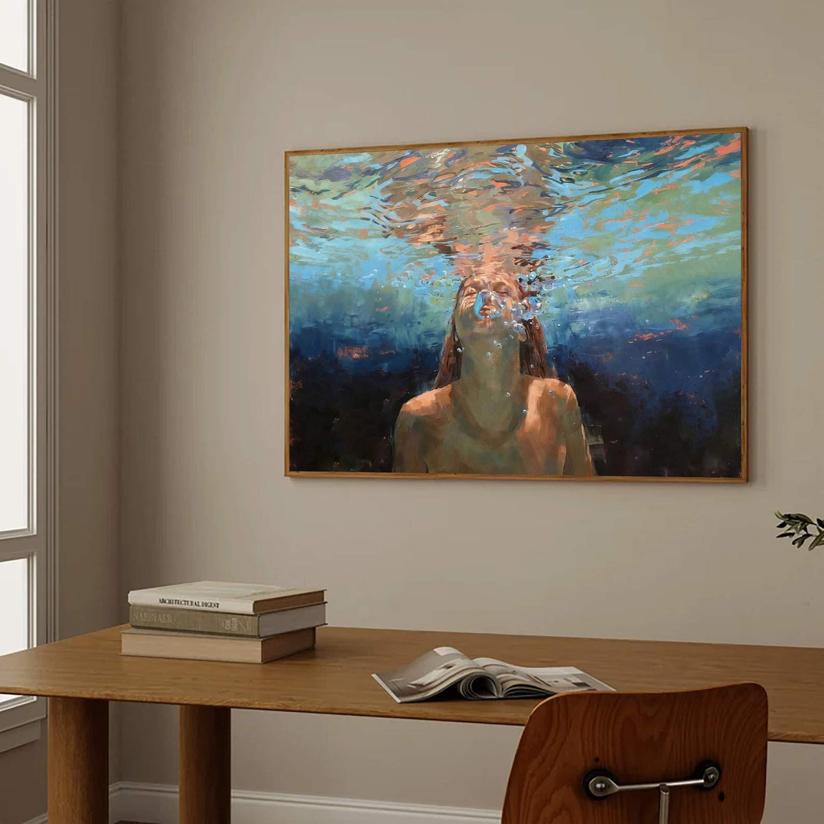 May include: A framed painting depicts a person underwater, with light filtering through the water. The artwork features a palette of blues, greens, and oranges, creating a serene and ethereal atmosphere. The painting is displayed on a neutral-colored wall.