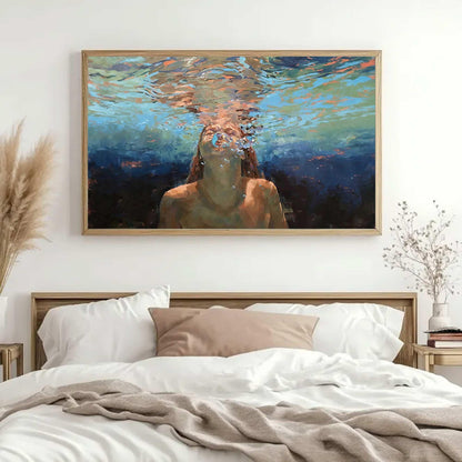 May include: A framed art print depicts a person underwater, exhaling bubbles. The painting features a palette of blues, oranges, and browns, with the subject's face and upper body visible. The artwork is displayed above a bed with white linens.