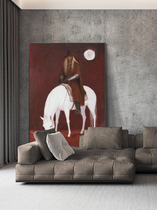 May include: A large canvas painting depicts a person in brown riding a white horse under a full moon. The background is a deep red. The person wears a hat, cape, and armor. The painting is displayed above a brown sectional sofa with pillows.