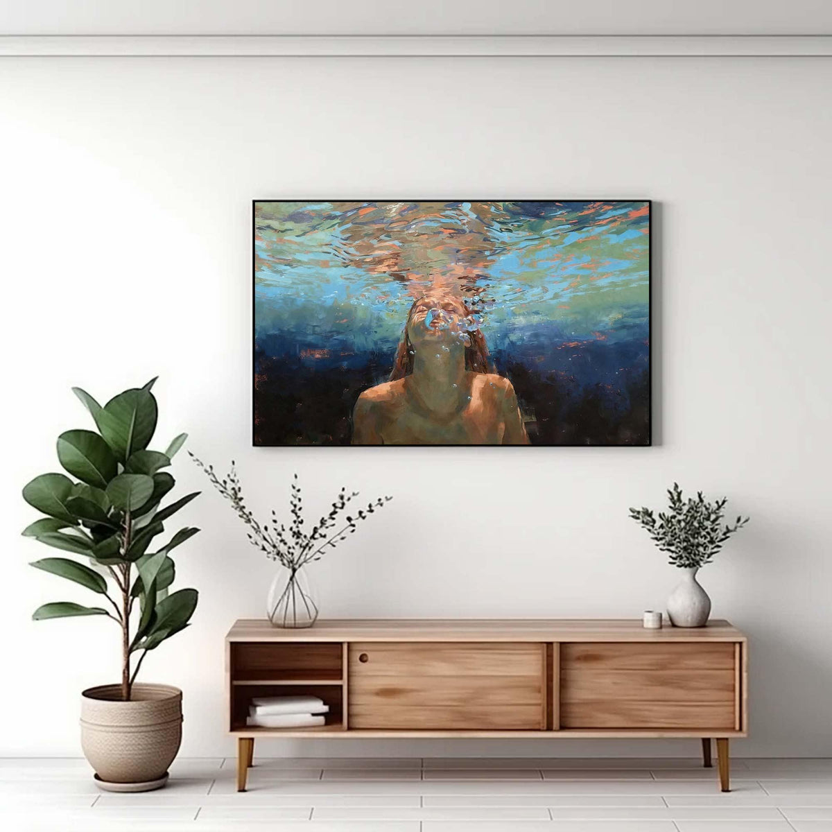 May include: An oil painting depicts a person underwater, with light refracting through the water's surface. The artwork is framed and hangs on a white wall above a wooden cabinet. A potted plant and decorative vases are also in the image.