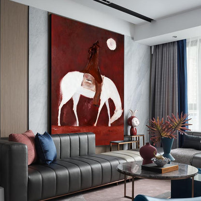 May include: Large abstract painting featuring a white horse with a rider against a deep red background. A full moon is depicted in the upper right. The artwork is displayed above a black leather sofa with decorative pillows, enhancing the modern interior design.