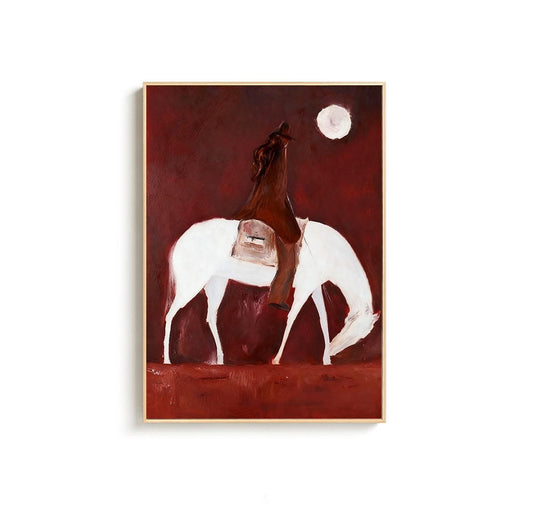 May include: An abstract painting of a cowboy on a white horse under a full moon. The cowboy is wearing a brown coat and hat. The background is a deep red color, and the painting is framed in a light wood.