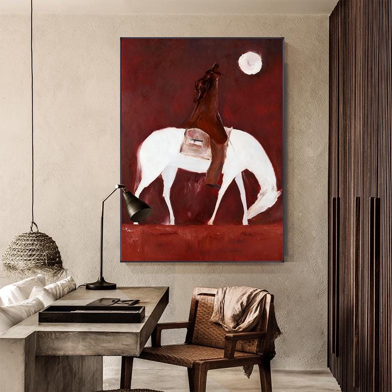 May include: Abstract painting of a rider on a white horse against a deep red background. The artwork features a full moon and a minimalist style, with the rider and horse as the central focus. The painting is mounted on a wall.