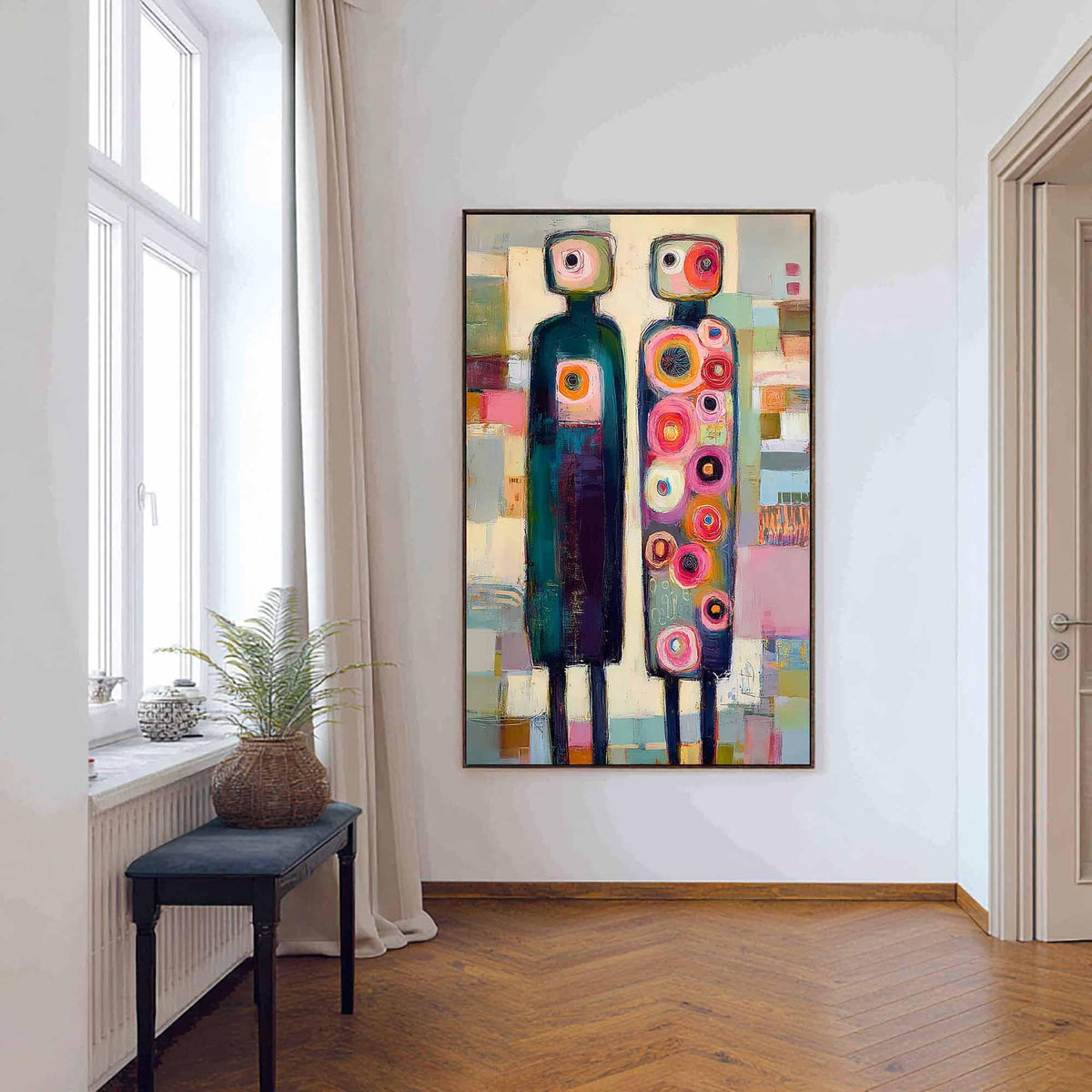 May include: A rectangular wall painting featuring two stylized, tall, thin figures standing side-by-side. The left figure is dark teal with a single circular chest detail, while the right figure is covered in numerous colorful, concentric circles.