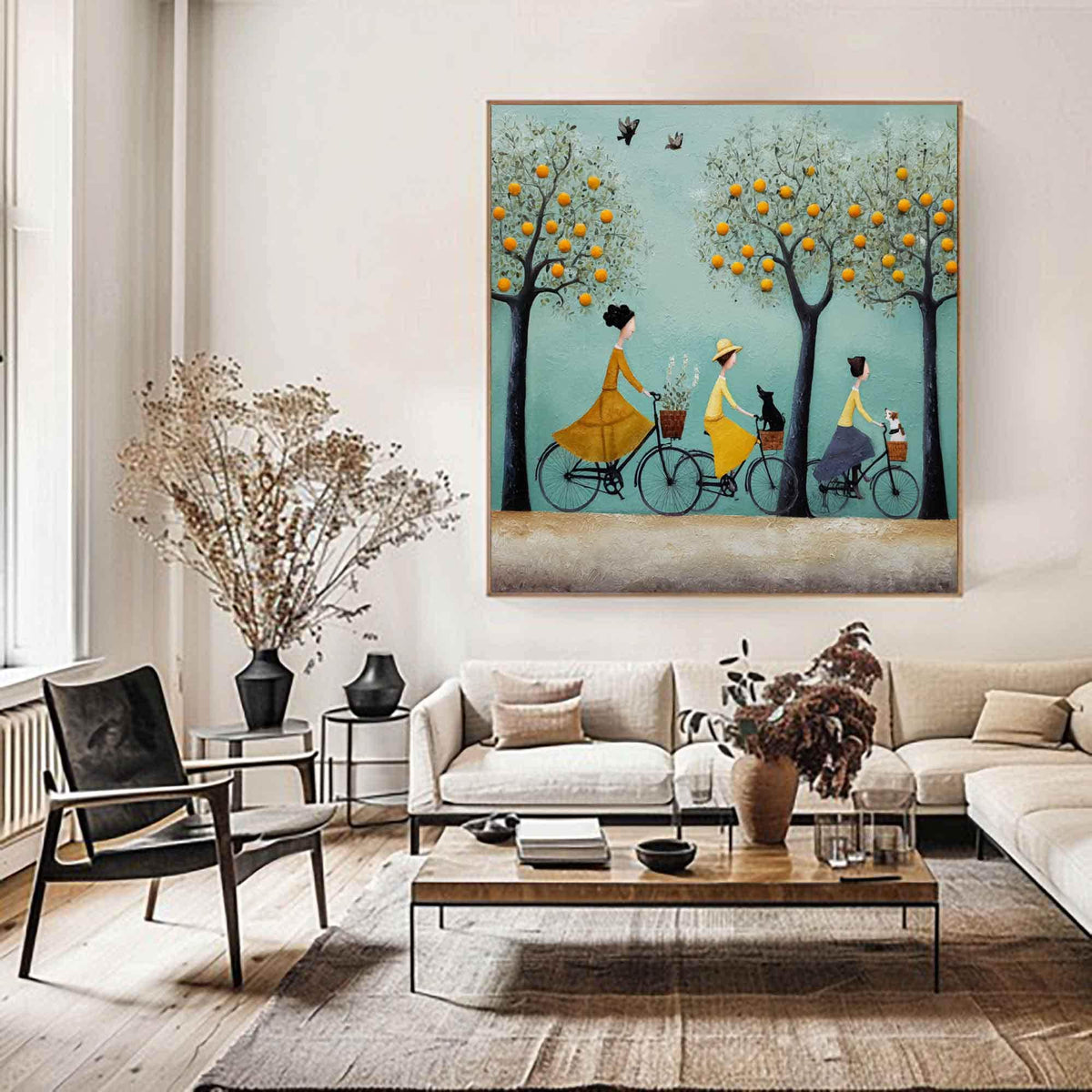 May include: A framed painting depicts three figures riding bicycles beneath trees with orange fruit. Each bicycle has a basket, and one carries a black cat, another a white dog. The background is a light blue with birds.