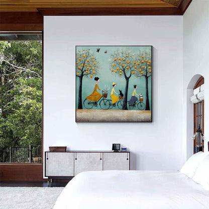 May include: A framed painting depicts three figures riding bicycles beneath trees laden with orange fruit. The figures wear yellow and blue dresses and hats. A black cat and a small dog are in the bicycle baskets. The background is a light blue sky.