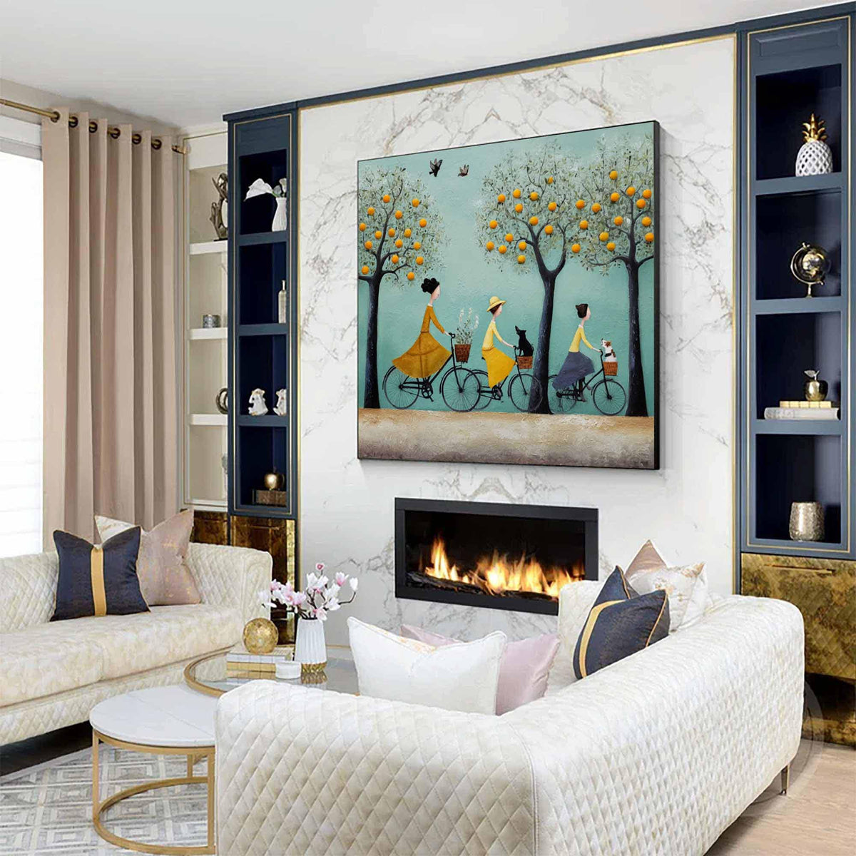 May include: A framed wall art piece depicts three figures riding bicycles under orange trees. The figures wear dresses in yellow and blue. The artwork hangs above a fireplace in a living room with a white sofa and decorative pillows.