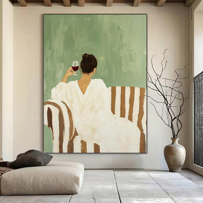 May include: An abstract painting depicts a person in a white dress seated on a striped sofa, holding a glass of red wine. The background is a muted green, and the overall aesthetic is minimalist and serene. A vase with branches is on the right.