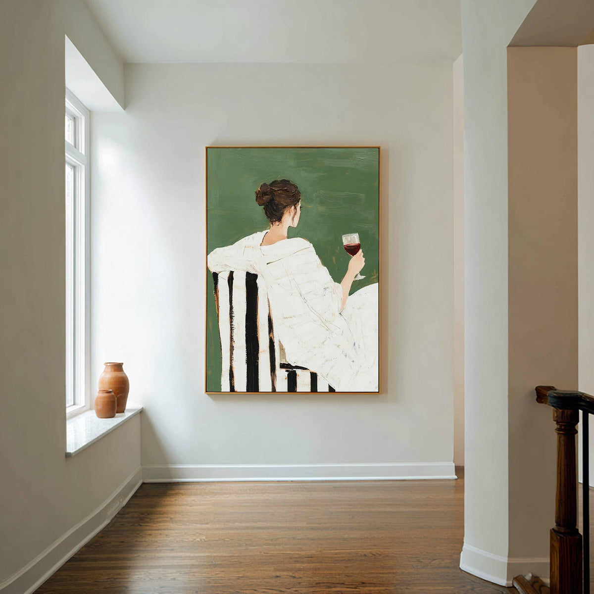 May include: An art print depicts a person in a white outfit seated in a black and white striped chair, holding a glass of red wine. The background is a solid green color, and the artwork is framed in gold. The painting evokes a sense of leisure and relaxation.