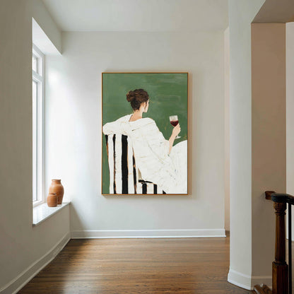 May include: An art print depicts a person in a white outfit seated in a black and white striped chair, holding a glass of red wine. The background is a solid green color, and the artwork is framed in gold. The painting evokes a sense of leisure and relaxation.