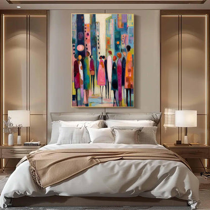 May include: An abstract painting depicting a cityscape with colorful buildings and figures. The artwork features a palette of blues, pinks, yellows, and oranges. The figures are stylized, with elongated forms. The painting is framed and hangs above a bed.