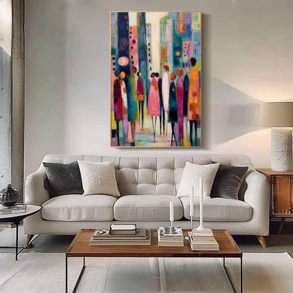 May include: Abstract cityscape painting with figures in vibrant colors. The artwork features a colorful urban scene with stylized buildings and people, framed in gold. The painting hangs above a light gray sofa with decorative pillows.