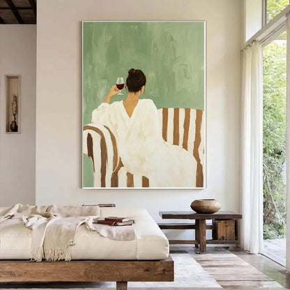 May include: An abstract painting depicts a person in a white dress seated on a striped sofa, holding a glass of red wine. The background is a muted green, and the sofa has brown and white stripes. The artwork is framed and mounted on a white wall.