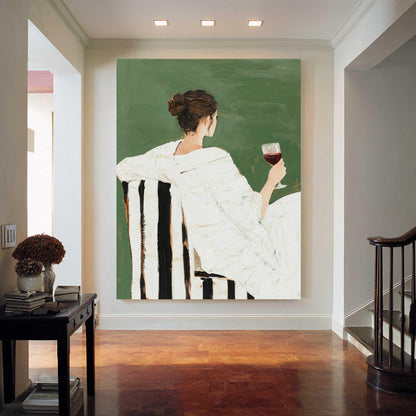 May include: An abstract painting depicts a person in a white robe seated in a black and white striped chair, holding a glass of red wine. The background is a solid green color. The artwork is displayed in a well-lit hallway with a dark wood floor.