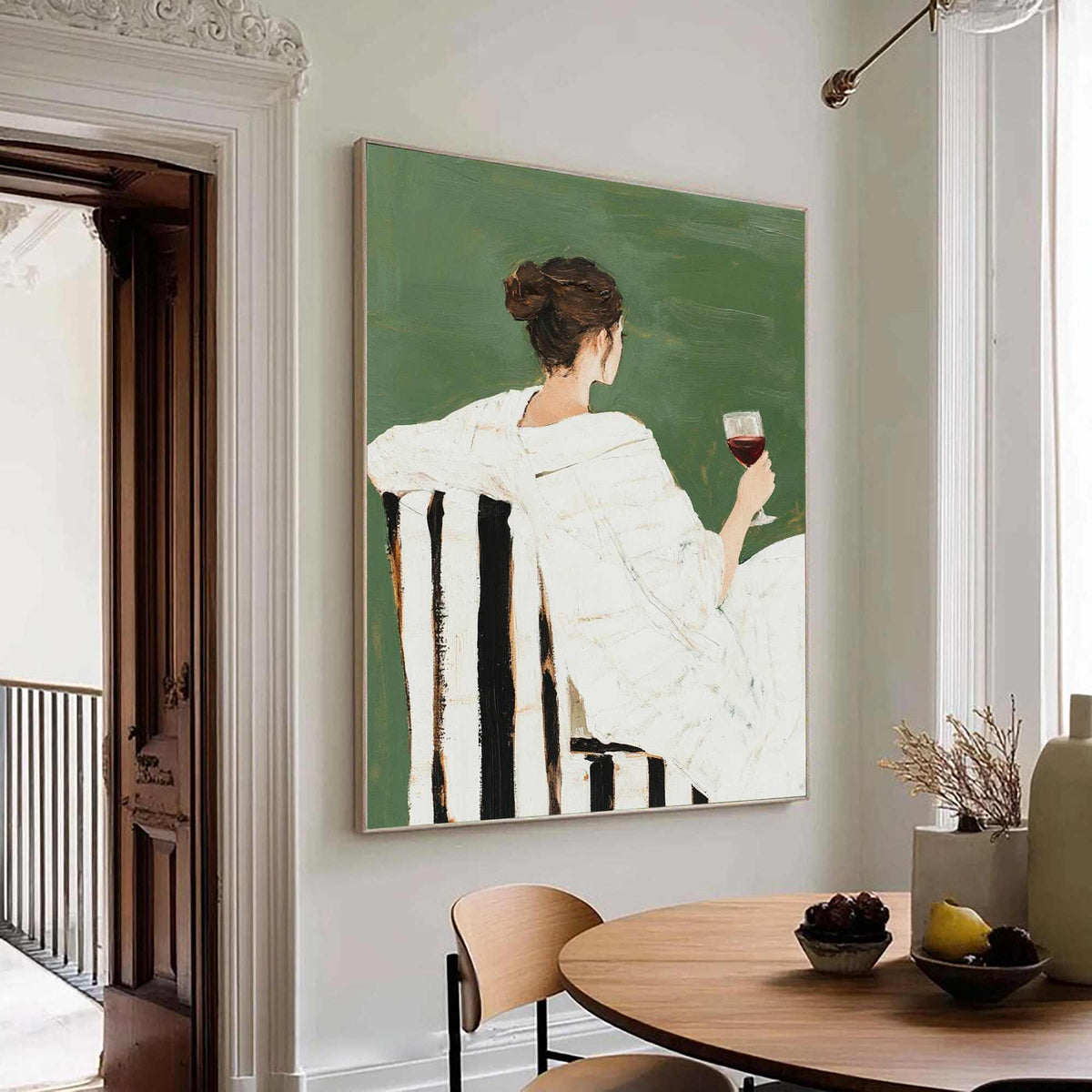May include: An abstract painting depicts a person seated in a chair, holding a glass of red wine. The figure is draped in white fabric against a green backdrop. The chair has black and white striped upholstery. The artwork is framed in a light-colored wooden frame.