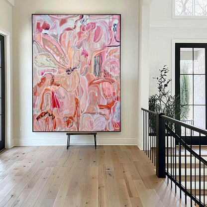 May include: Large abstract painting with a black frame. The artwork features a complex composition of pink, peach, and white brushstrokes. The painting is displayed in a bright, modern entryway with hardwood floors.