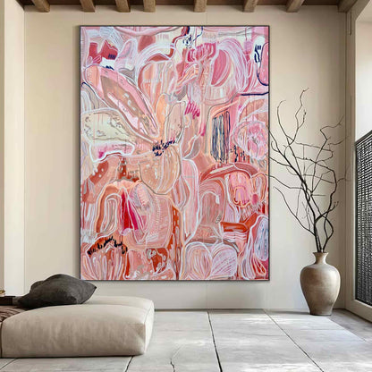 May include: Large abstract painting with a floral theme. The artwork features a blend of pink, peach, and white hues, with bold brushstrokes and intricate details. The painting is framed and displayed in a modern living space.