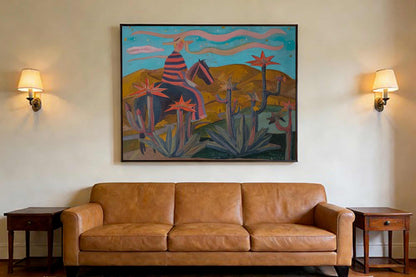 May include: A large framed painting depicting a figure on horseback in a desert landscape, above a brown leather sofa. The painting features a rider in a striped shirt and a horse, with cacti and mountains in the background. Two wall sconces flank the painting.