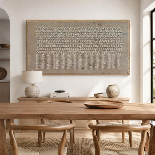 May include: A large rectangular wall art piece featuring a textured beige and cream abstract design with raised circular and vertical line patterns, framed in light wood, displayed above a wooden sideboard with a lamp and decorative bowls.
