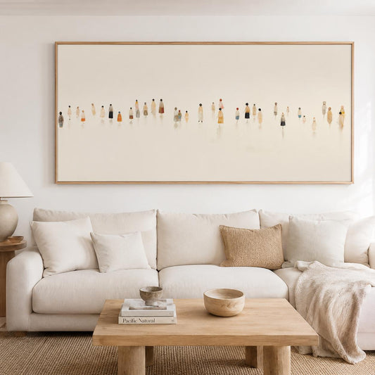 May include: A large rectangular framed artwork depicts a minimalist scene of numerous figures in various colors. The figures are arranged horizontally against a light background. The artwork hangs above a cream-colored sectional sofa with a wooden coffee table.
