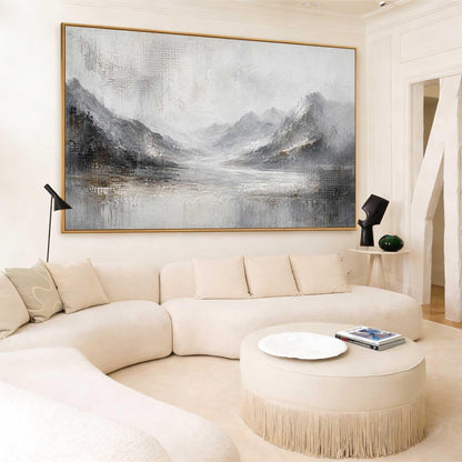 May include: A large rectangular landscape painting in a gold frame featuring a mountain range and a body of water in shades of gray, white, and black. The artwork displays textured brushstrokes and abstract details, depicting a serene scene.