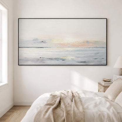 May include: Abstract landscape painting in a black frame. The artwork features a serene seascape with soft pastel colors of white, blue, and peach. The painting evokes a sense of calm and tranquility, perfect for home decor.