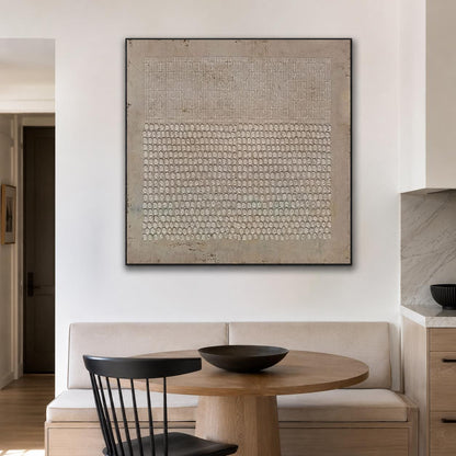 May include: A square wall art piece featuring a beige background with a textured upper section of vertical lines and a lower section of repeating circular patterns, all enclosed within a thin black frame, displaying a neutral color palette.