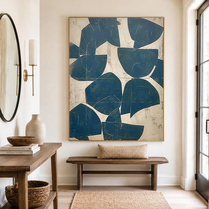 May include: A large rectangular wall art piece featuring a series of deep blue, semi-circular and abstract geometric shapes layered over a textured, off-white background. The artwork is framed in a thin, light-toned wood frame and hangs vertically.