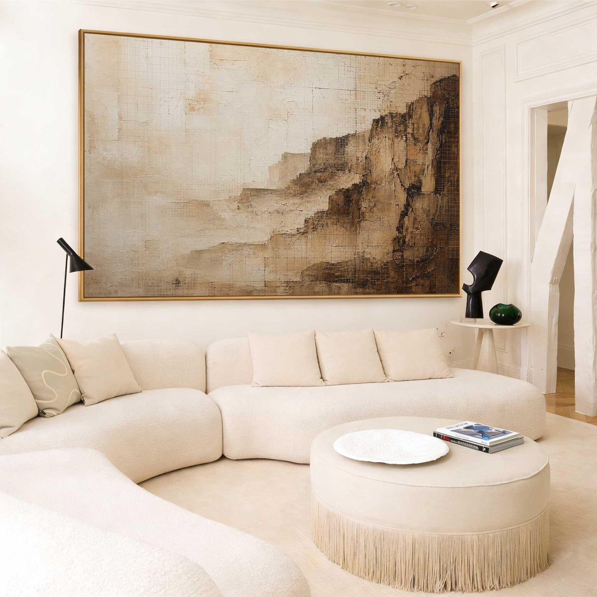 May include: A large rectangular wall art piece featuring an abstract landscape in shades of beige, cream, and dark brown. The painting displays textured, layered brushstrokes that suggest a rocky cliffside or canyon, framed in a thin gold border.