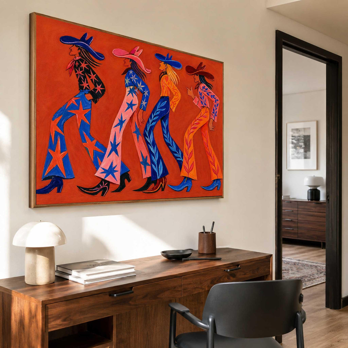 May include: A rectangular wall art piece featuring a vibrant orange background with four stylized figures walking in a line. Each figure wears a wide-brimmed hat, a patterned long-sleeved top, flared trousers decorated with star or leaf motifs, and boots.
