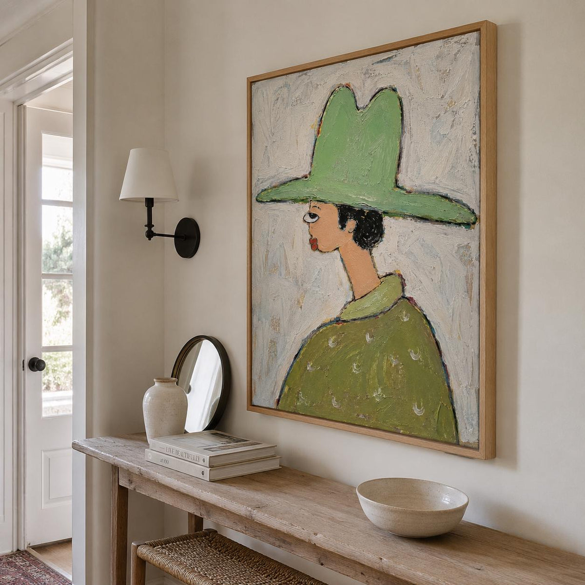 May include: A square framed painting depicting a stylized figure in profile wearing a large, wide-brimmed light green hat and a matching green collared shirt with white circular patterns, set against a textured, off-white, and light blue background.