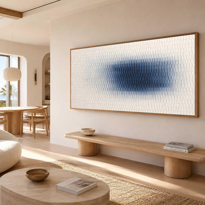 May include: A large rectangular wall art piece featuring a textured surface with a gradient pattern. The artwork transitions from white on the outer edges to a deep blue center, composed of small, repeating rectangular shapes in a wooden frame.