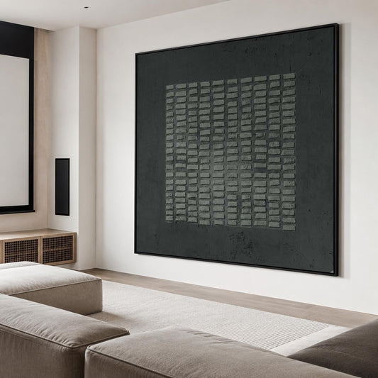 May include: A large, rectangular wall art piece featuring a dark charcoal gray background with a central square composed of a grid of raised, textured, light gray rectangular blocks, all enclosed within a thin, black frame.