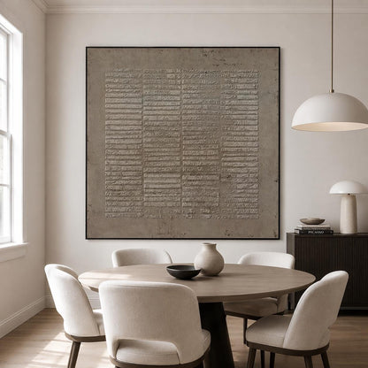 May include: A large square wall art piece featuring a textured, taupe-colored surface with a repeating pattern of horizontal raised rectangular segments arranged in vertical columns, all enclosed within a thin, dark, minimalist frame.