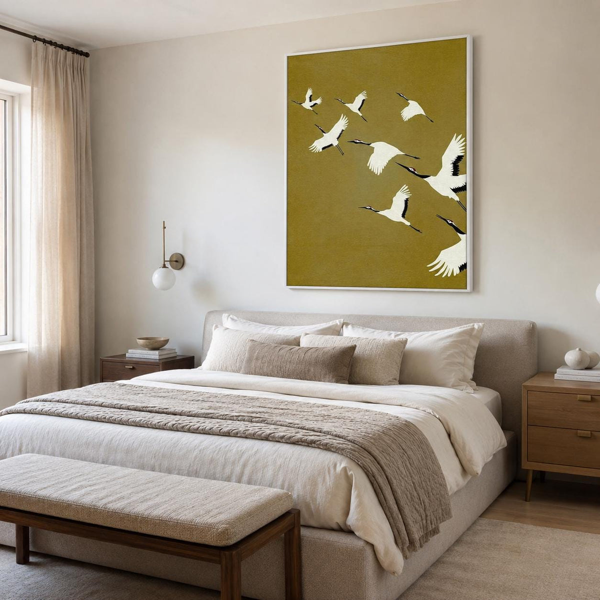 May include: A rectangular wall art print featuring a flock of white cranes with black wing tips and red crowns flying across a solid mustard yellow background, enclosed in a thin white frame and displayed above a neutral upholstered bed.