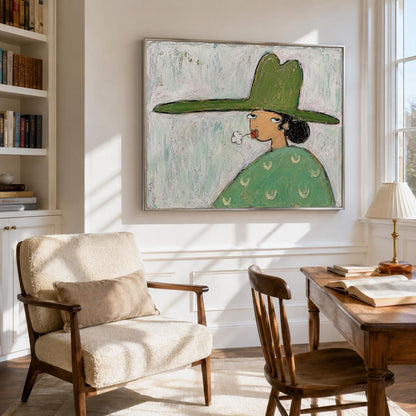 May include: A framed painting depicting a person wearing a wide-brimmed green hat and a green patterned shirt, blowing a small white puff of smoke from their mouth. The artwork features a textured, light-colored background with visible brushstrokes.