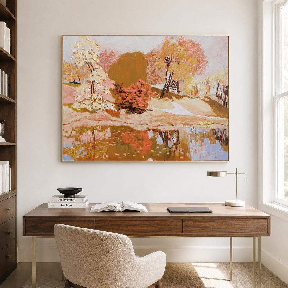 May include: A rectangular landscape painting in a gold frame featuring a park scene with trees in shades of orange, yellow, and cream, reflected in a calm body of water. The artwork uses textured brushstrokes to depict foliage and a path.