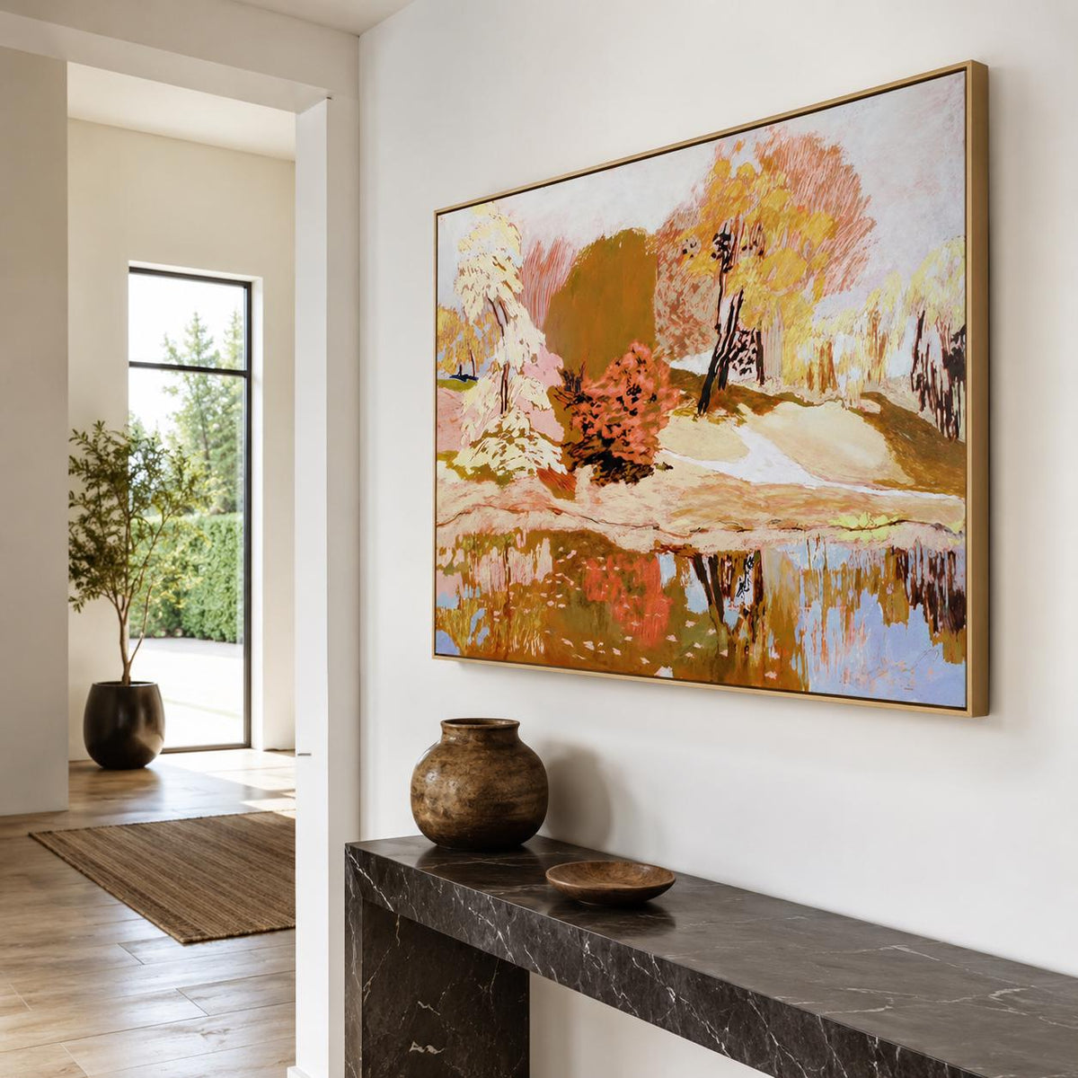 May include: A rectangular landscape painting in a gold frame featuring an autumn scene with yellow, orange, and brown trees reflected in a body of water. The artwork displays a textured application of paint with visible brushstrokes and earthy tones.