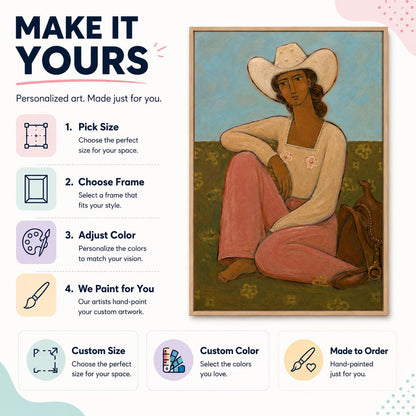 May include: A framed painting of a person wearing a white cowboy hat and a long-sleeved white shirt with pink floral accents, paired with pink pants. The person sits on a green field with a brown saddle beside them against a light blue sky.