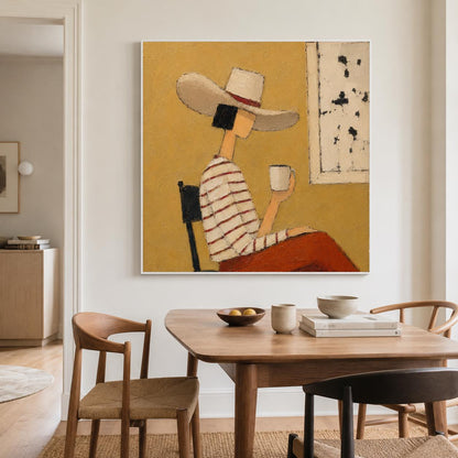 May include: A square wall art print featuring a stylized painting of a person wearing a wide-brimmed hat and a striped long-sleeve shirt, sitting on a chair while holding a white mug against a solid mustard yellow background with a white panel.