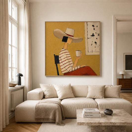 May include: A square wall painting featuring a figure wearing a wide-brimmed hat and a white and red striped shirt, sitting on a chair while holding a white mug. The background is a solid mustard yellow with a white rectangular panel on the right.