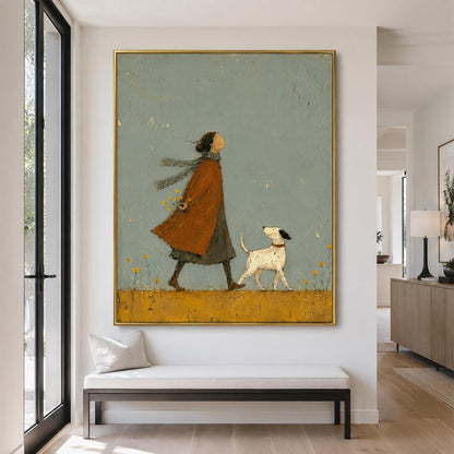 May include: A framed wall art print featuring a stylized illustration of a person in a long orange coat and a grey scarf walking with a small white dog with black spots. The scene is set against a muted sage green background with yellow flowers.