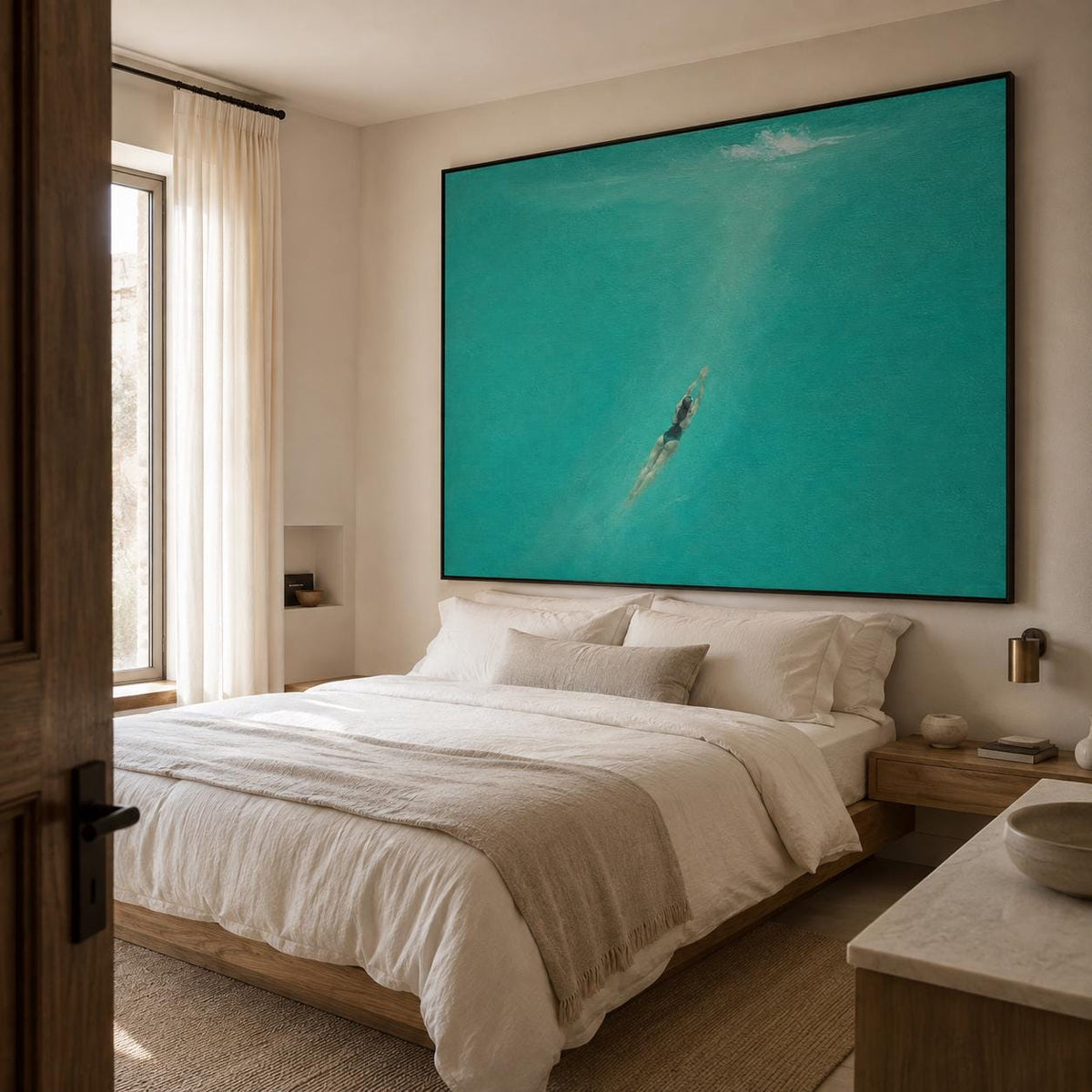 May include: A large rectangular wall art piece featuring a swimmer in a dark swimsuit diving into vibrant turquoise water. The artwork is displayed above a bed with white bedding, a beige throw blanket, and pillows in a neutral-toned bedroom setting.