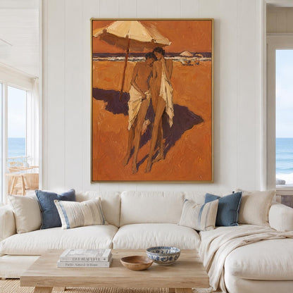 May include: A vertical rectangular oil painting in a gold frame depicting two figures standing on a sandy beach under a large umbrella. The scene is rendered in warm shades of orange and brown, showing the figures draped in white fabric.